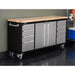 Trinity TLS-7205 (72x19) Black & Stainless Steel Rolling Workbench with all drawers closed. Placed against a wall.