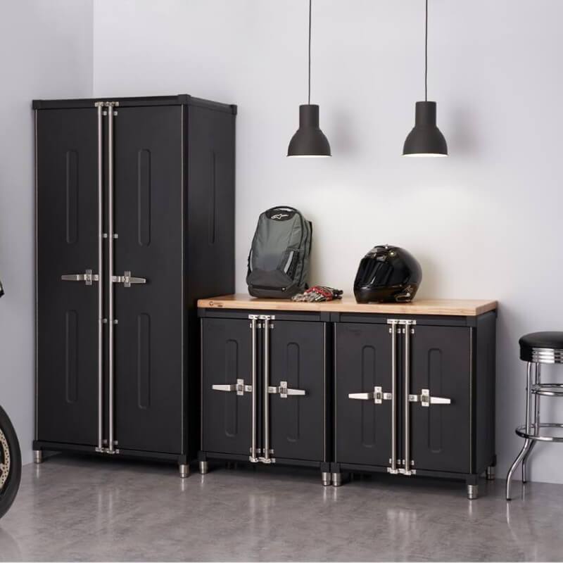 Trinity TSNPBK-0615 (4-Piece) PRO Garage Cabinet Set in Black Placed Against a Wall in a Garage with Drawers Closed.